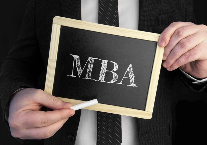 businessman holds up chalkboard with text mba 1568x1095 1